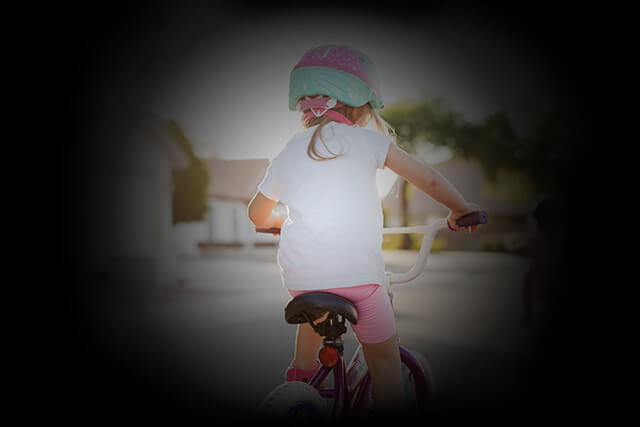 Simulation of vision with glaucoma, shows a child riding a bike within a narrow viewport.
